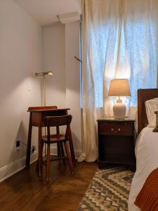 Antique writing desk with brass lamp and nightstand in Room 16 at Stanton House Inn