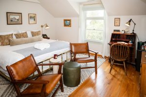 Room 32's king bed, seating area, and desk