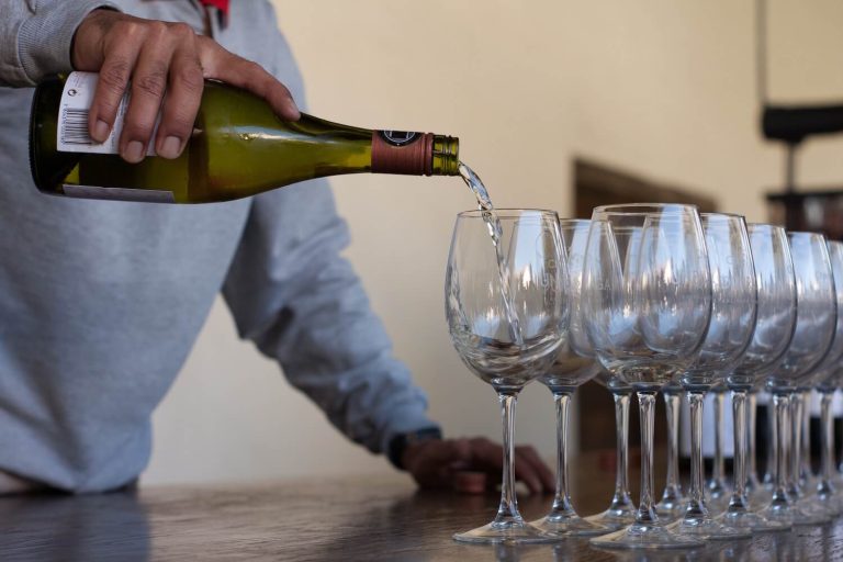 man pouring wine into bottles at a tasting at one of the best wineries in ct on the connecticut wine trail