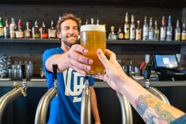 A bartender working in the craft beer industry serving a brewski at Two Roads Brewing Company & Area Two Experimental Brewing