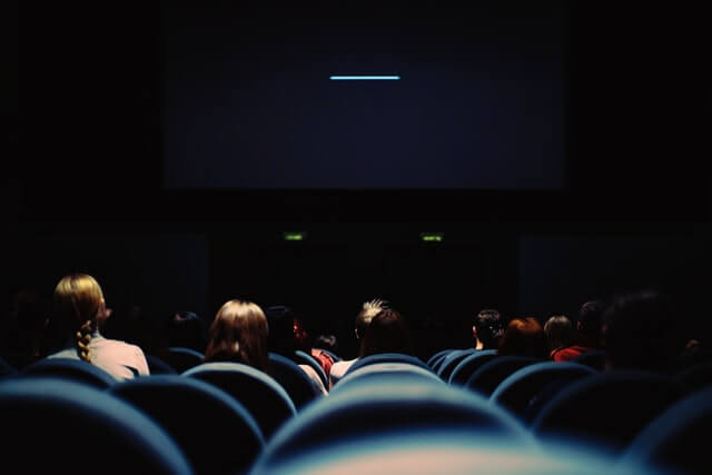 inside of a movie theatre, waiting for the start of the movie