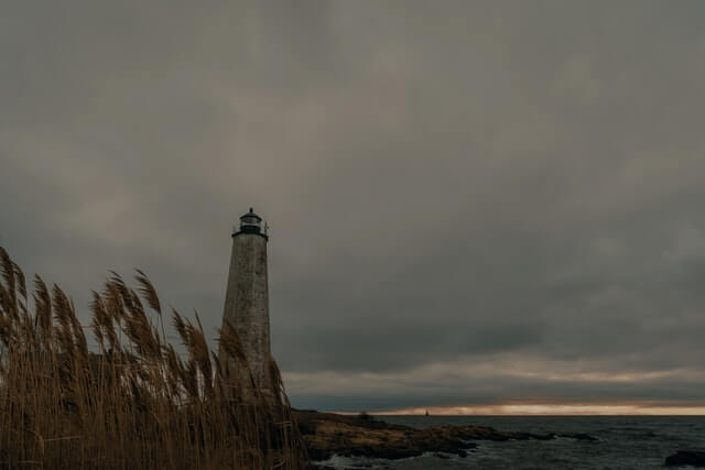 the lighthouse under a cloudy sky at lighthouse point park in new haven, connecticut