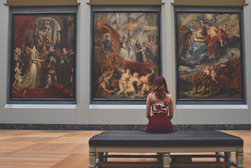 woman sitting in front of art at a local art museum
