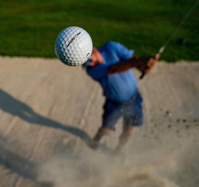 player getting a ball out of a sandtrap at one of the best public golf courses near greenwich ct