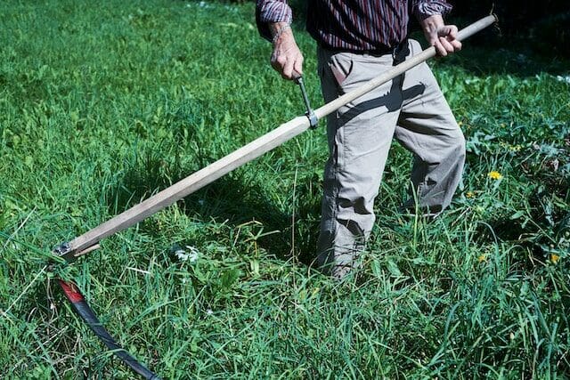 Man displaying an antique scythe at the Connecticut Antique Machinery Association
