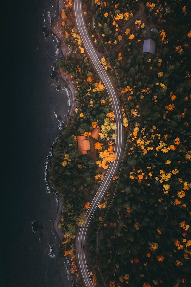 aerial shot of a scenic coastal road in the fall