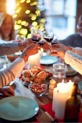 Family and friends dining at home celebrating Thanksgiving in CT with traditional food like a roast turkey and seasonal side dishes