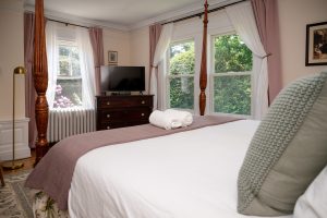 King bed and TV in the Brush Suite, with windows looking both south and west of the house