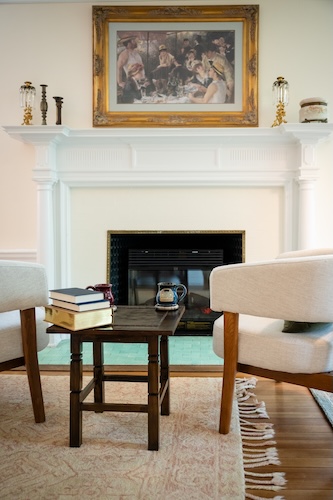 Comfortable chairs beside the antique fireplace in the Brush Suite
