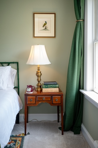 Nightstand with a mug and books in Room 12