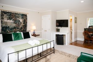 View of Room 14's bed, bath, TV, and desk from the seating area