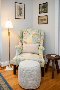 The chair closer to the bed in the Sackett Suite, complete with somewhere to put a drink, somewhere to put your feet up, and plenty of art on the walls