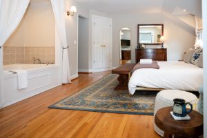 View of the ensuite bathroom, Whirlpool tub, and bed in the Sackett Suite