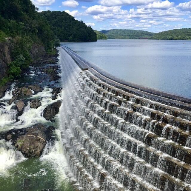 A view of the Croton dam in Croton-on-Hudson, NY with a park and a river in the background