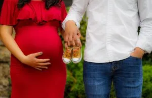 Soon to be parents making the announcement before taking advantage of babymoon packages