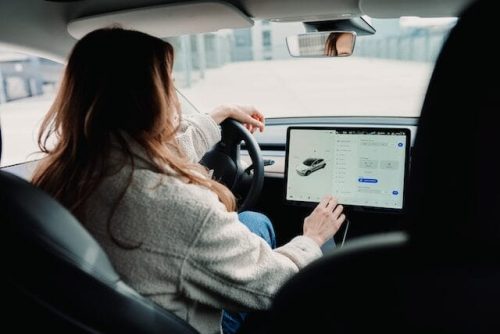 Woman touching a tablet in a car, a perfect gift, on her cross country road trip to national parks