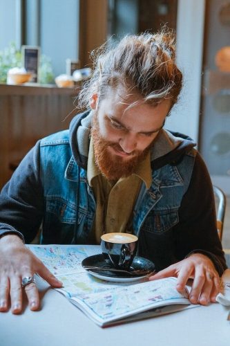 A person looking at a map while planning a road trip and perusing gift ideas for road trip travelers