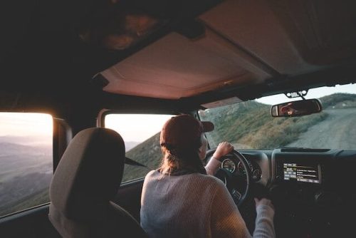 Woman driving along a ridge at sunrise