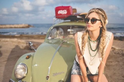 Road tripper sitting in front of a beetle along the shoreline