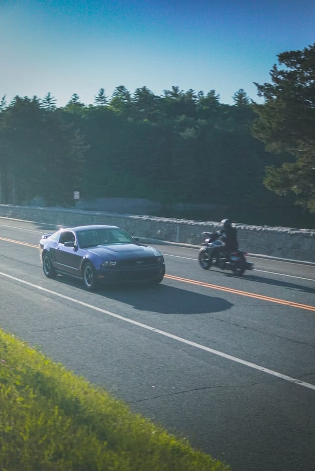Expensive car passing a motorcycle on a Madison, Connecticut, road