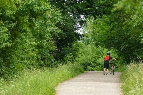 Child pushing a bike along the Cheney Rail Trail
