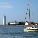 A small sailboat motors out of the Connecticut River's mouth near Old Saybrook, Connecticut.