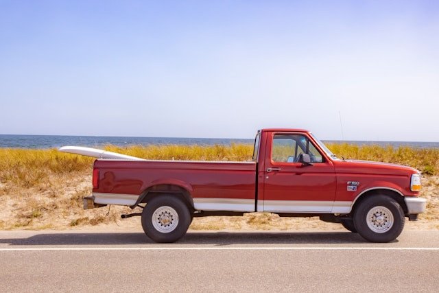 Truck parked near the point from which to access Moshup Beach, with a surfboard in back