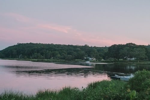 Boats on Mystic River at sunset, close to one of the best weekend getaways in New England for the summer