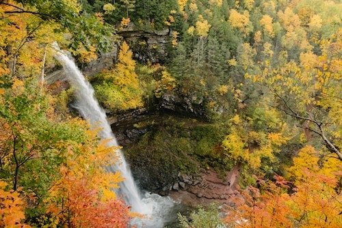 Fall foliage surrounding a waterfall along the best hikes in upstate New York