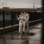 Couple walking on a rainy day from their wedding venue on Long Island Sound