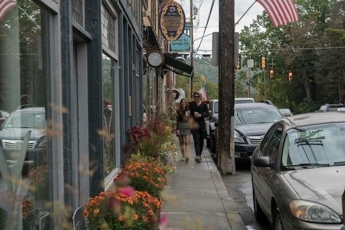 Man and woman walking along the sidewalk of the main street of Narrowsburg, NY