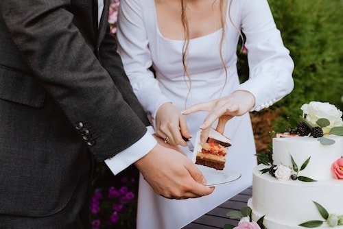 Cutting the cake with the groom in a sports coat after morning ceremonies at a wedding reception