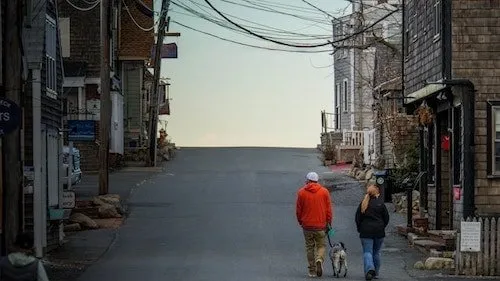 Man and woman walking their dog through the streets of Rockport, MA