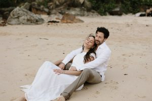 A couple enjoying a private moment on a public beach during their Connecticut elopement, marriage license at the ready