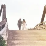 newly wed couple walking across a bridge at one of the best small wedding venues in CT