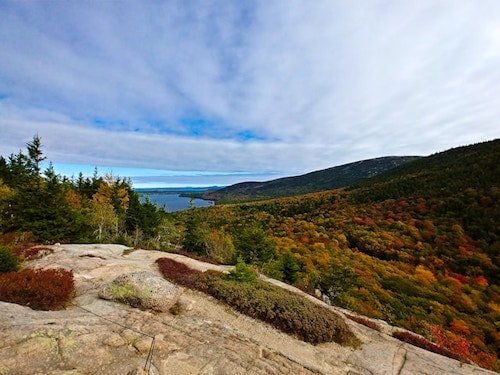 Hiking trail with vibrant fall colors in Acadia National Park, Maine