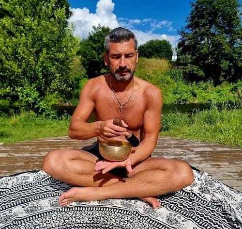 Man guiding a retreat feeling fully relaxed during one of the meditation sessions with sound healing at one of the best retreat centers