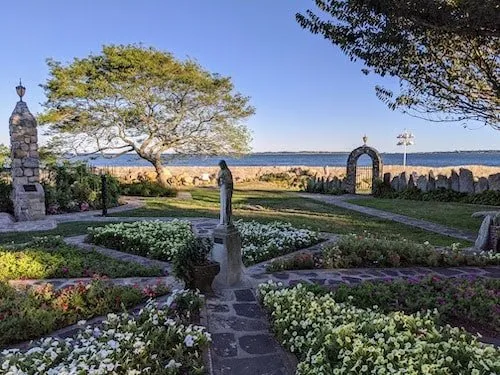 A garden facing the coast, with sacred art like a small statue of Our Lady of Peace