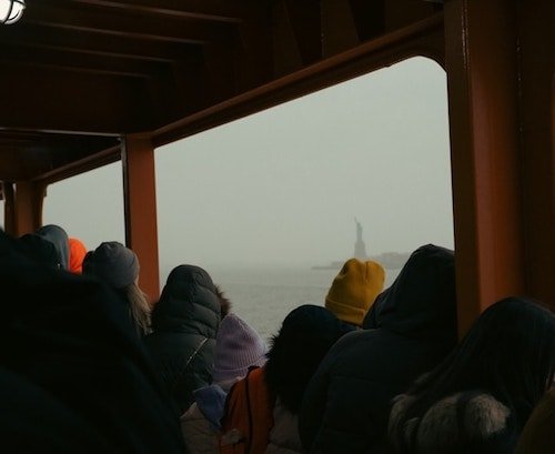 Checking out the Statue of Liberty and Ellis Island from the free Staten Island ferry as it passes through the harbor of New York in February