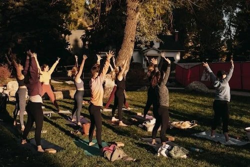 Group of people practicing yoga in a serene outdoor setting