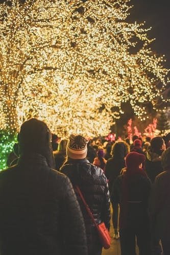Crowds walking under holiday lights in December in New England