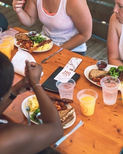 Women enjoying home fries on a business trip breakfast