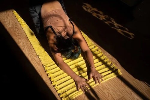 Solo woman at yoga practice, in the Child's Pose or Balasana on the yoga mat