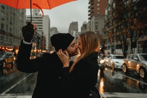 Couple sharing a tender moment during a rainstorm in New York in February