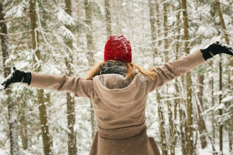 Woman, bundled up, enjoying the snow while hiking from NYC