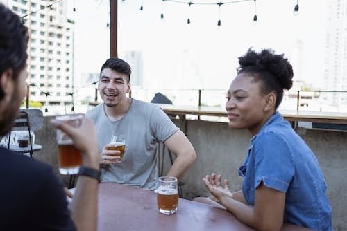 Friends enjoying a warm afternoon together at a rooftop bar with live music