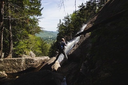 Photographer capturing a waterfall on an outdoor adventure in the summer months in New Hampshire