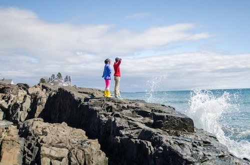 Kids admiring the waves on rocks before the temperatures soar