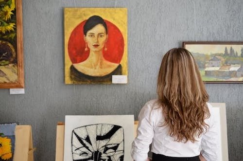 Woman admiring art on the walls of one of the numerous art galleries and music venues in the area