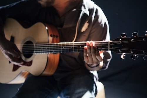 Man holding acoustic guitar, ready to play at one of the best ct wineries with live music